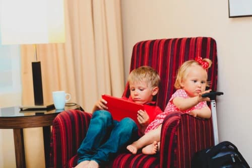 Bored kids sitting on hotel sofa