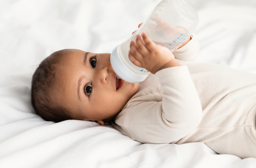 infant drinking milk from bottle