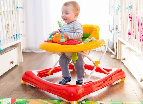 smiling toddler using a walker